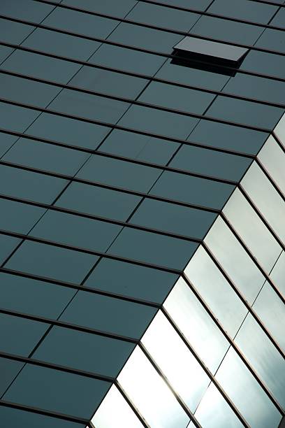 istock Angled green sunlit facade of glass skyscraper 490776557