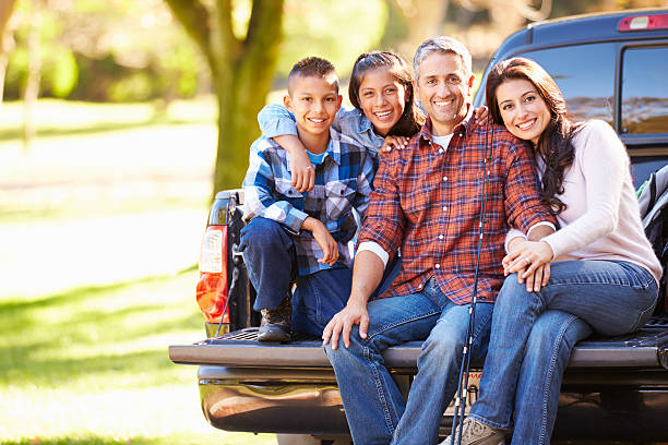 family sitting in pick-up truck auf camping-urlaub - family four people smiling autumn stock-fotos und bilder