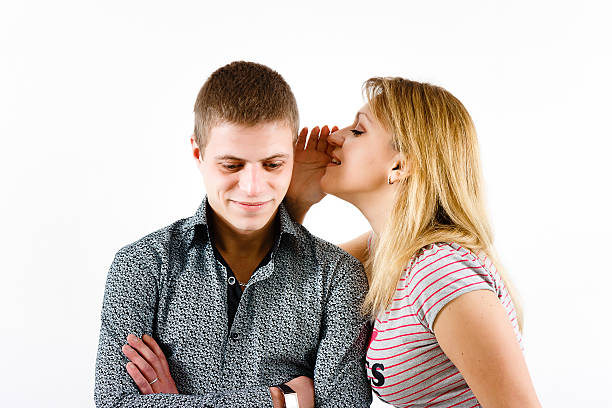 young woman whispering a secret stock photo