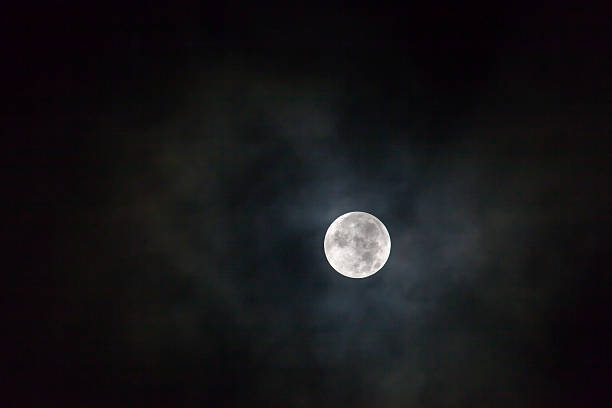 This dramatic photo illustration of a nighttime scene with brightly lit clouds and large, full, Blue Moon would make a great background for many uses.