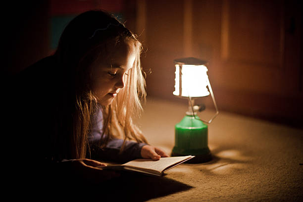 istock Girl reading book in lighting lamp 490780538