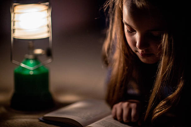 istock Girl reading book in lighting lamp 490781030