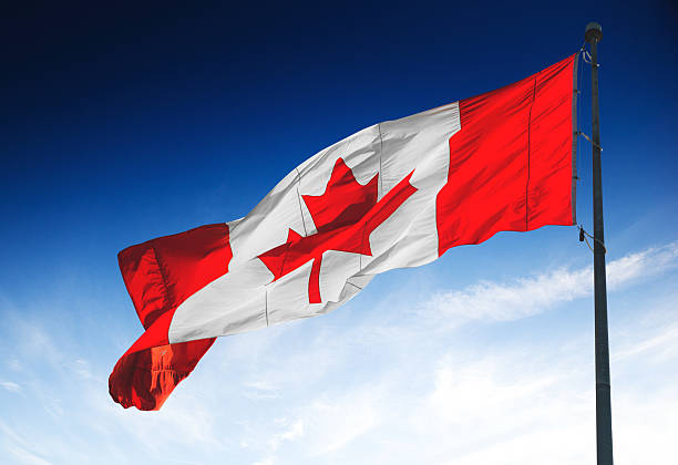 istock canadian flag waving on the blue sky 490781262