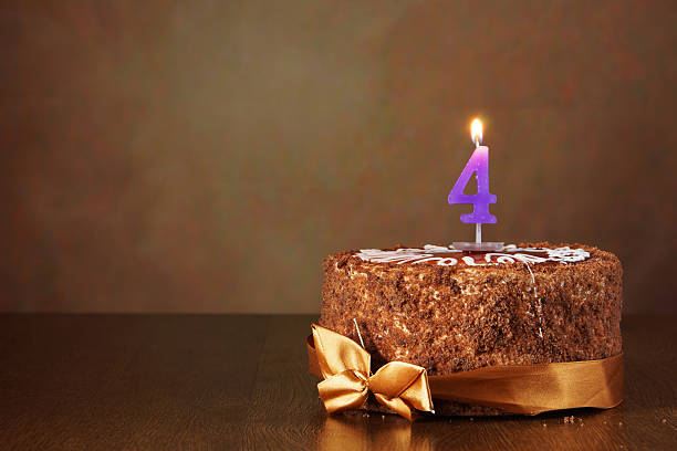istock Birthday chocolate cake with burning candle as a number four 490784142
