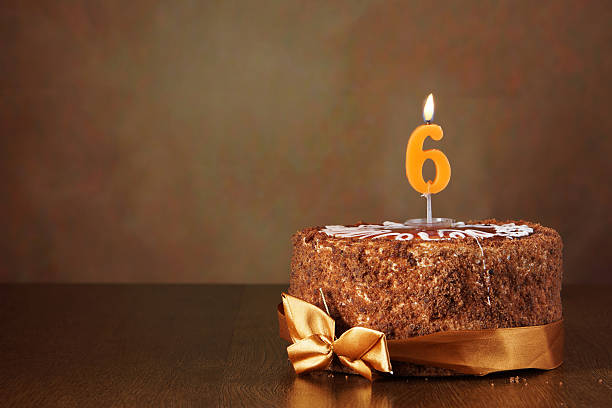istock Birthday chocolate cake with burning candle as a number six 490784260