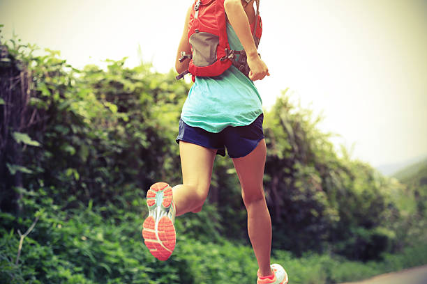 trail runner athlete running on forest trail. trail runner athlete running on forest trail. woman fitness jogging workout wellness concept. off track running stock pictures, royalty-free photos & images