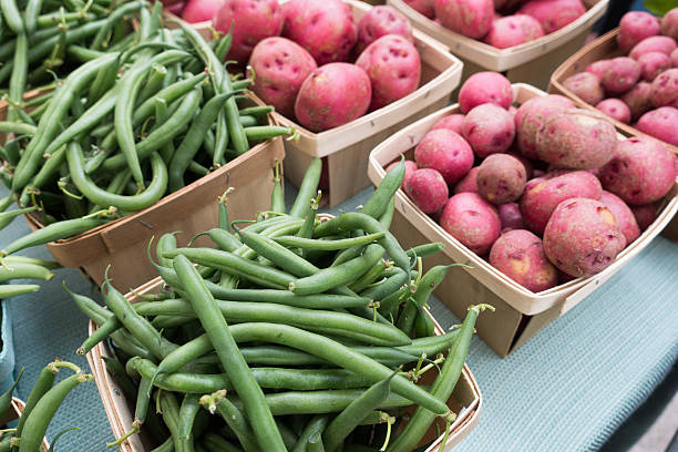 зеленая фасоль на завязках и небольшими картофеля в farmers market - red potato raw potato market red стоковые фото и изображения