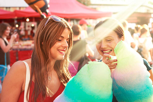 young women eating cotton candy and enjoying outdoor stock photo