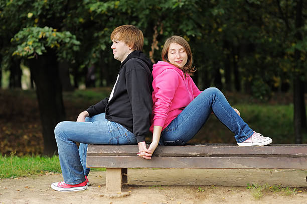 istock Young couple sitting on the bench in park 490799997