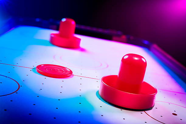 istock Dramatic lit air hockey table with puck and paddles 490800359