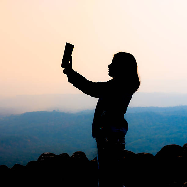 istock young woman selfie during Sunset on mountain with landscape view 490802462