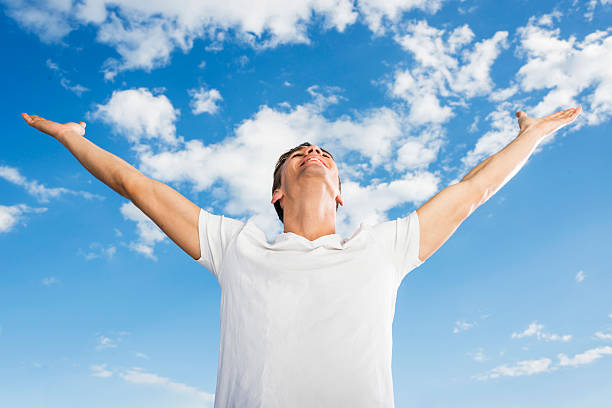 istock Below view of a man celebrating against blue sky. 490816258