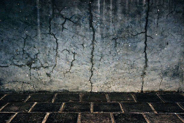 istock Cracked concrete wall background with cobble stones 490818584