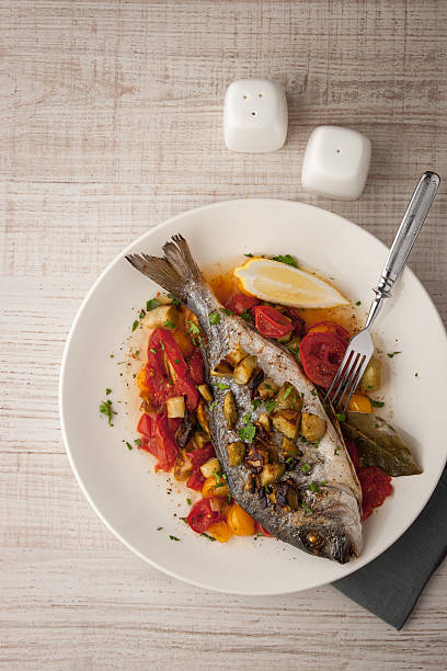 istock Fried dorado with vegetables, lemon and fork  top view 490821480