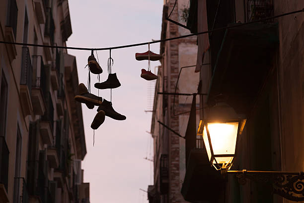 istock Dirty Sneakers hanging on the clothesline silhouette 490822192