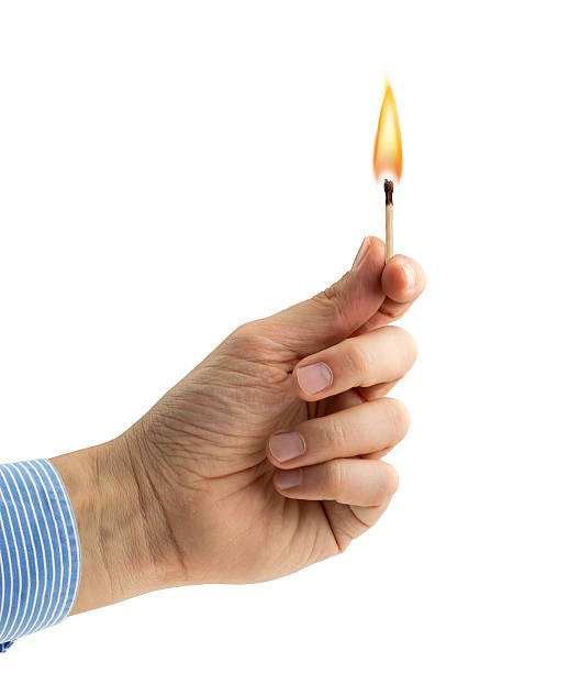 hand holding a burning matchstick hand holding a burning matchstick on white background lit match stock pictures, royalty-free photos & images