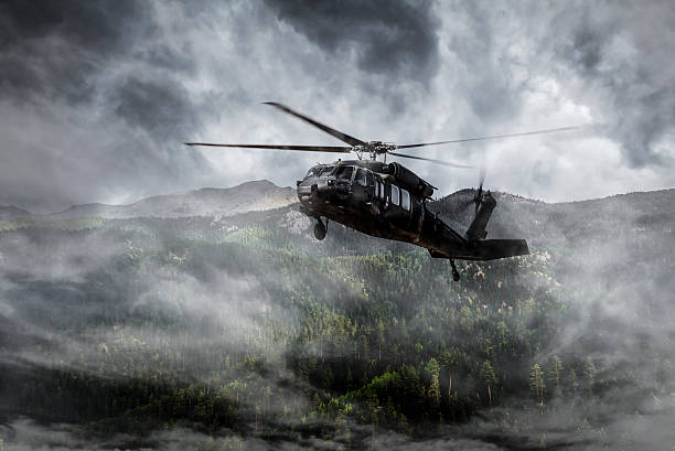 istock Army Helicopter Flies over Foggy Mountains 490823500
