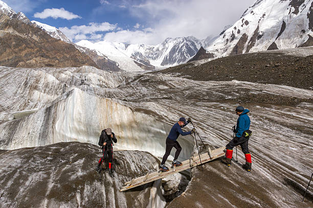 personnes traversant glacier crevasse sur bois séquences filmées via une passerelle - crevasse photos et images de collection