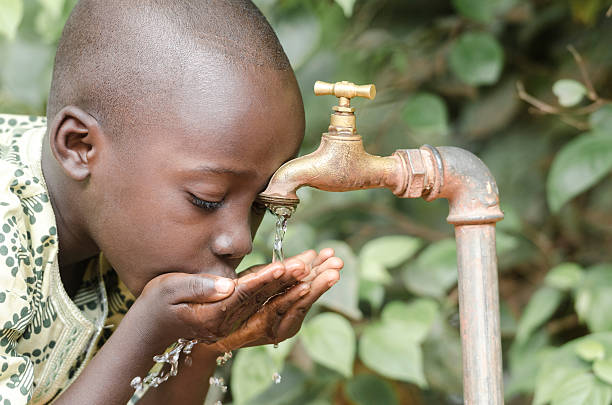 African Black Boy Drinking Fresh Clean Water Water scarcity is still affecting one sixth of Earth's population. African Children in developing countries suffer most from this problem, that causes malnutrition and health problems. developing countries photos stock pictures, royalty-free photos & images