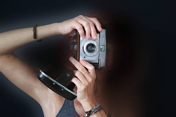 istock Woman Photographer With Old Analog Camera Black Background 490824260