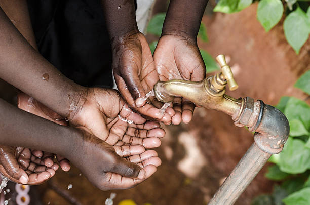 ブラックのベビー手のアフリカ世界水のタップ発行 - homelessness human hand dirty unhygienic ストックフォトと画像