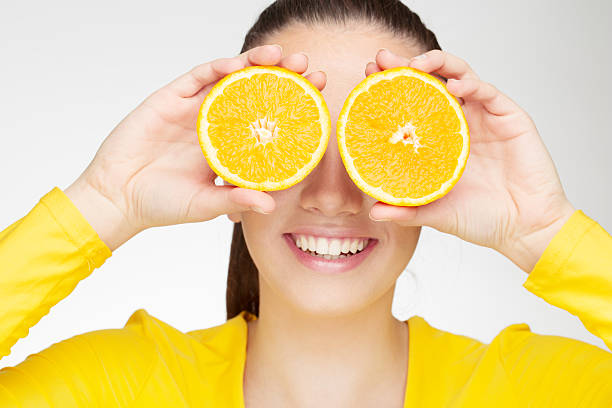 istock Young brunette woman with orange fruit 490824519