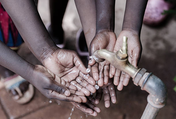 limpiar salpicaduras de agua en las manos de niños africanos metaphore de vida - baby child poverty water fotografías e imágenes de stock