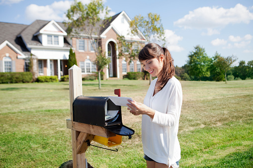 Beautiful american housewife checking mail box