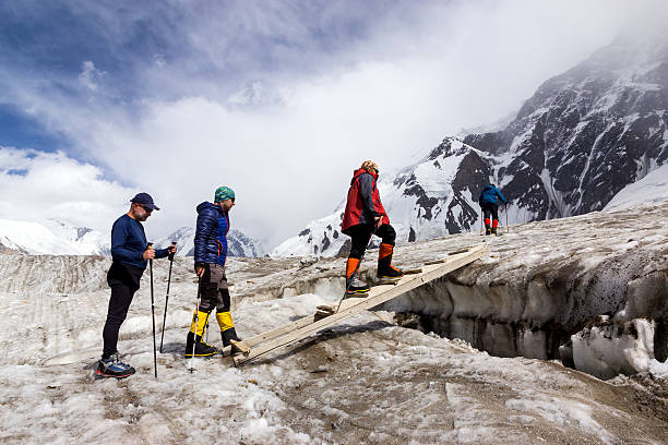 personnes traversant glacier crevasse sur bois séquences filmées via une passerelle - crevasse photos et images de collection