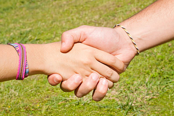 istock Man and woman with multicolored bracelets holding hands. 490827332