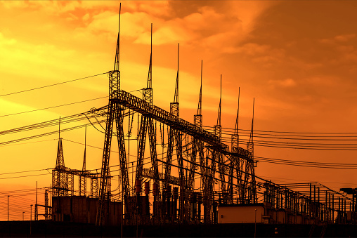 High voltage power transformer substation, sunset sky