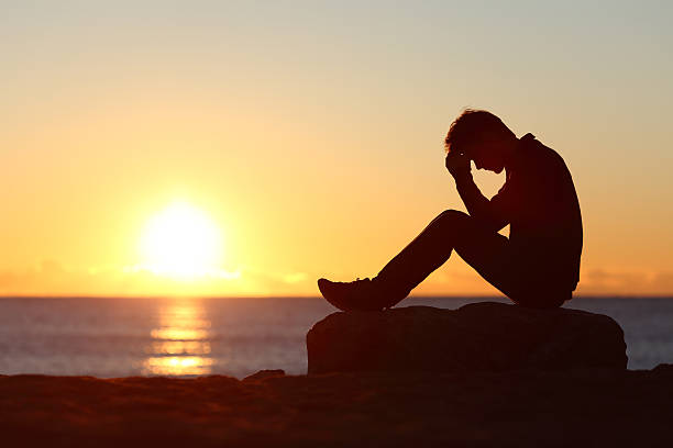 istock Sad man silhouette worried on the beach 490847418