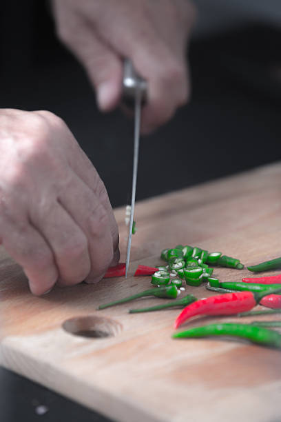 istock chili peppers being cut on a wooden board 490847490