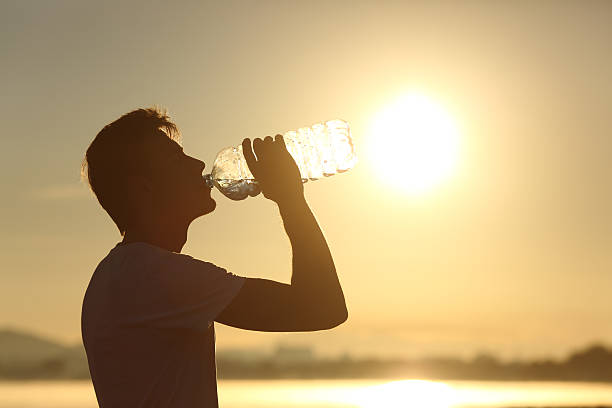 istock Fitness man silhouette drinking water from a bottle 490847676