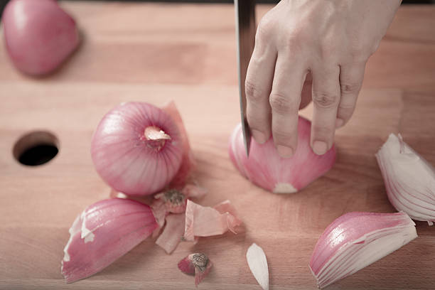 istock red onions being sliced on a wooden board 490848562