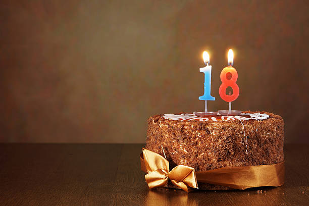 istock Birthday chocolate cake with burning candles as a number eighteen 490848936