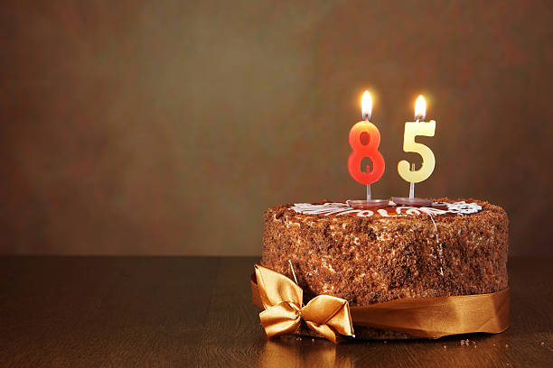 istock Birthday chocolate cake with burning candles as number eighty five 490849086