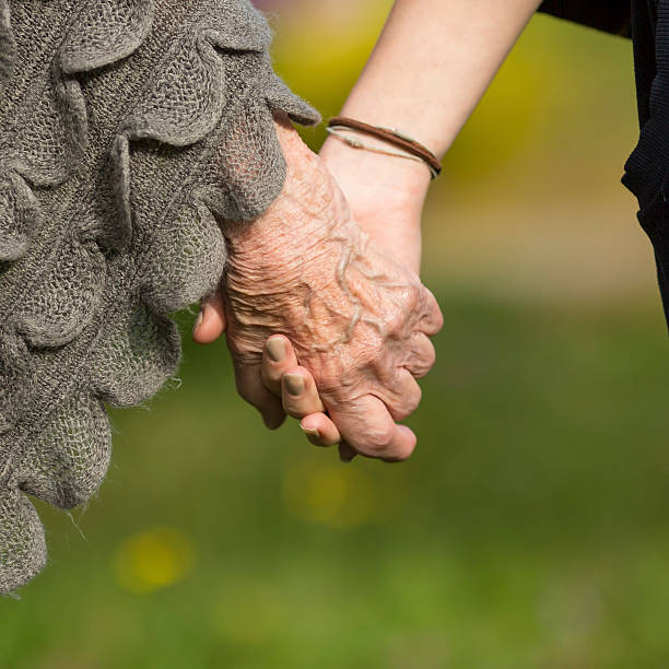 istock Elderly holding a young hand, close-up hands 490849524