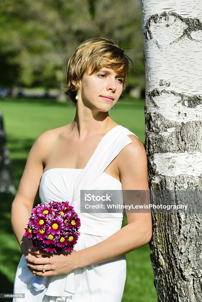 Bride Happy bride leaning on tree.  20-29 Years Stock Photo