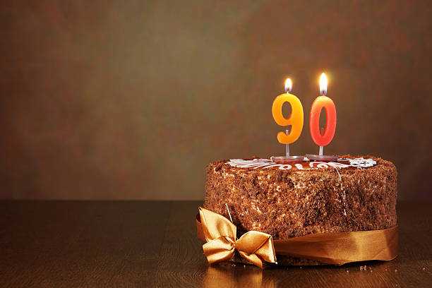 istock Birthday chocolate cake with burning candles as a number ninety 490850464