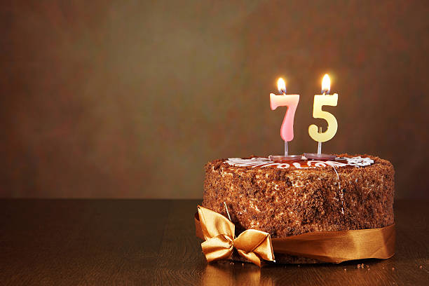 istock Birthday chocolate cake with burning candles as number seventy five 490850846