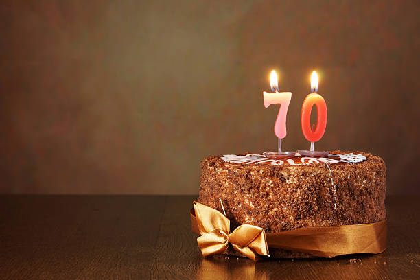 istock Birthday chocolate cake with burning candles as a number seventy 490850980