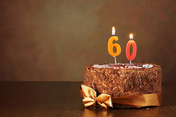 istock Birthday chocolate cake with burning candles as a number sixty 490851210