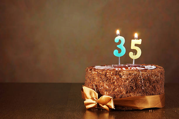 istock Birthday chocolate cake with burning candles as number thirty five 490851328