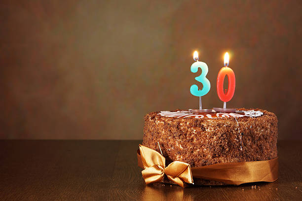 istock Birthday chocolate cake with burning candles as a number thirty 490851436