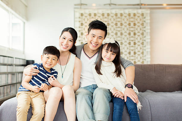 Young Chinese Family in Apartment Portrait of a young Chinese family in their Hong Kong apartment. chinese ethnicity stock pictures, royalty-free photos & images