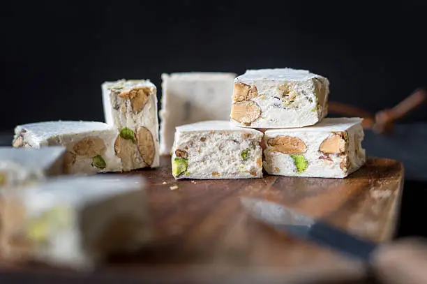 Traditional italian (torrone) and spanish (turron) Christmas dessert, made of honey, sugar, egg whites and roasted almonds and pistachios