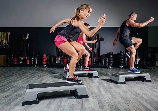 istock Woman trainer doing aerobic class with steppers in gym 490857908