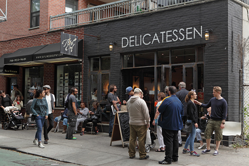 New York, NY, USA - September 27, 2015: People line up to buy lunch from Mile End Delicatessen on Hoyt Street, Boerum Hill, Brooklyn, New York. Mile End is a Jewish delicatessen which serves smoked meats and fish, pickles, and bagels, breads, drinks, and pastries. The deli has become a local favorite and has expanded with locations in other NYC neighborhoods.