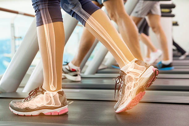 Highlighted ankle of woman on treadmill Digital composite of Highlighted ankle of woman on treadmill human joints medical stock pictures, royalty-free photos & images